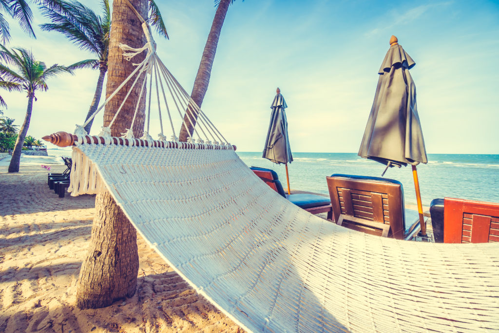 Empty hammock on the tropical beach and sea with umbrella and chair - Vintage Filter